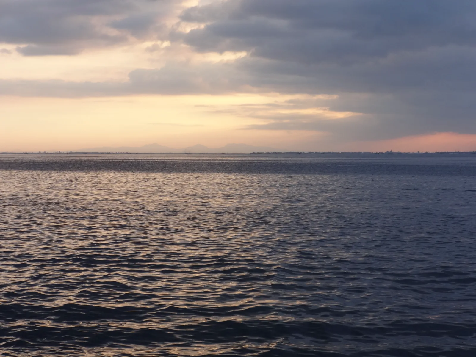The sun setting over Manila Bay, seen from the seaside walkway beside the Mall of Asia in Pasay.